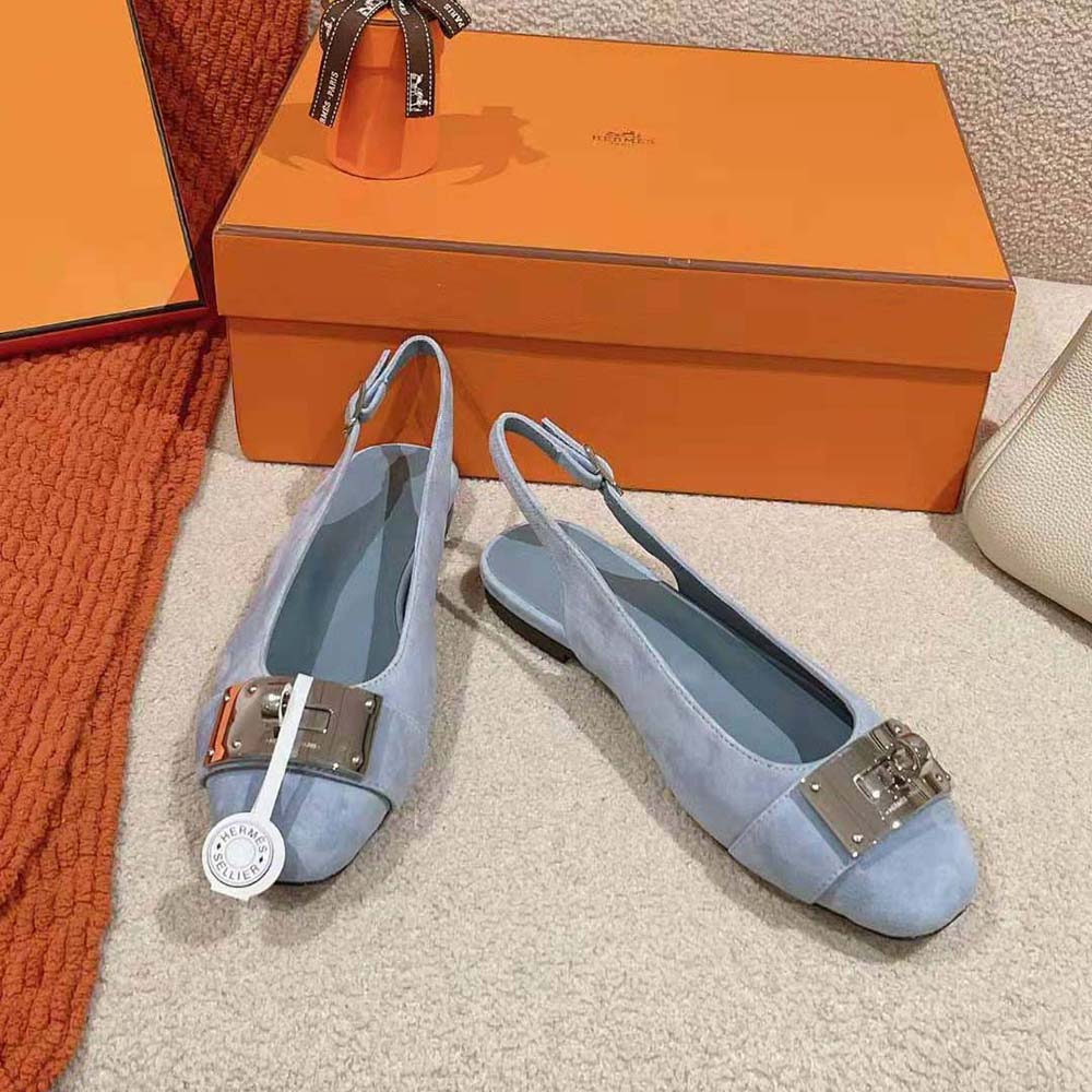 Close-up of signature Hermes hardware on blue suede slingback