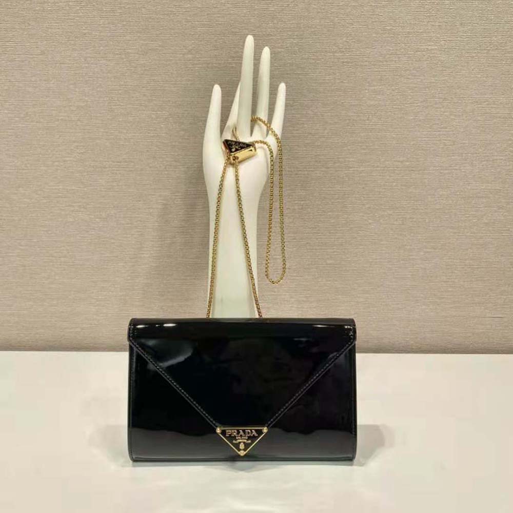 Close-up of silver Prada logo hardware on black patent leather mini-bag