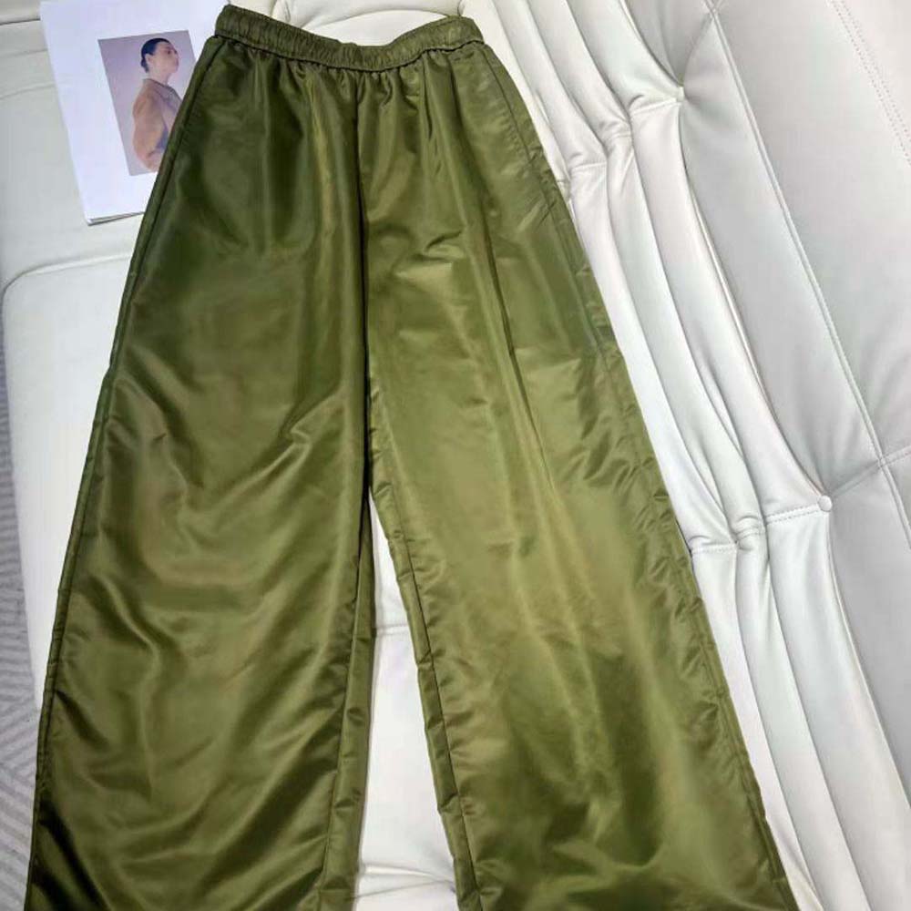 Close-up of branded Prada hardware on green Re-Nylon pants waistband