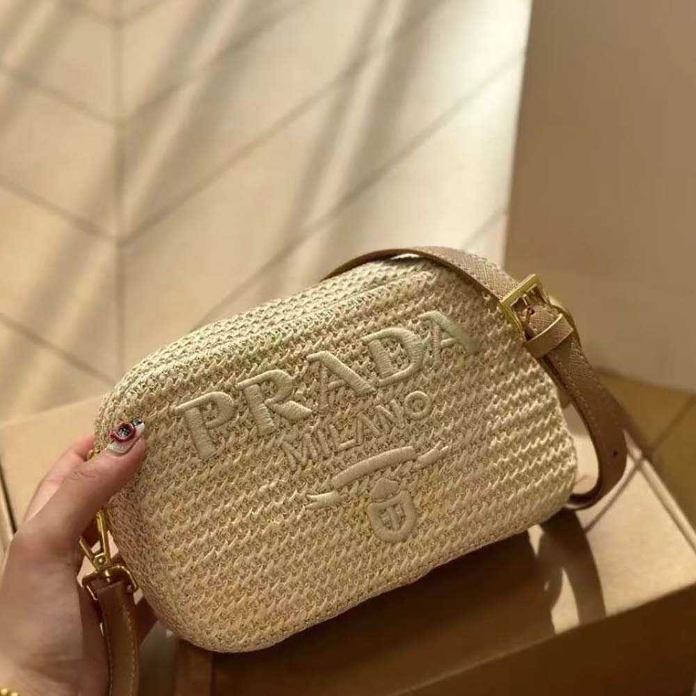 Close-up on silver-tone Prada logo detail and woven texture