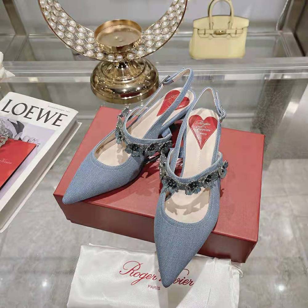 Front angled shot of navy denim slingback pumps by Roger Vivier
