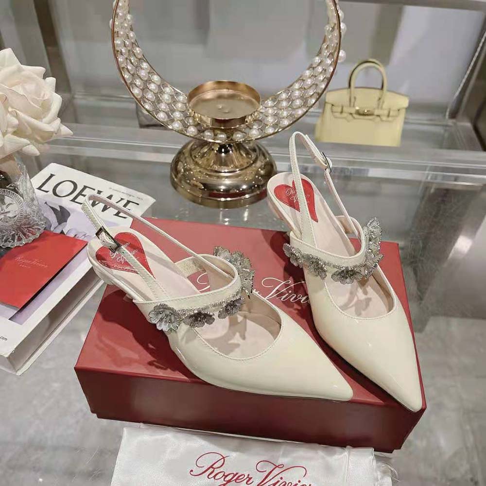 Angle showing white patent leather and slingback strap on Roger Vivier Virgule Pumps