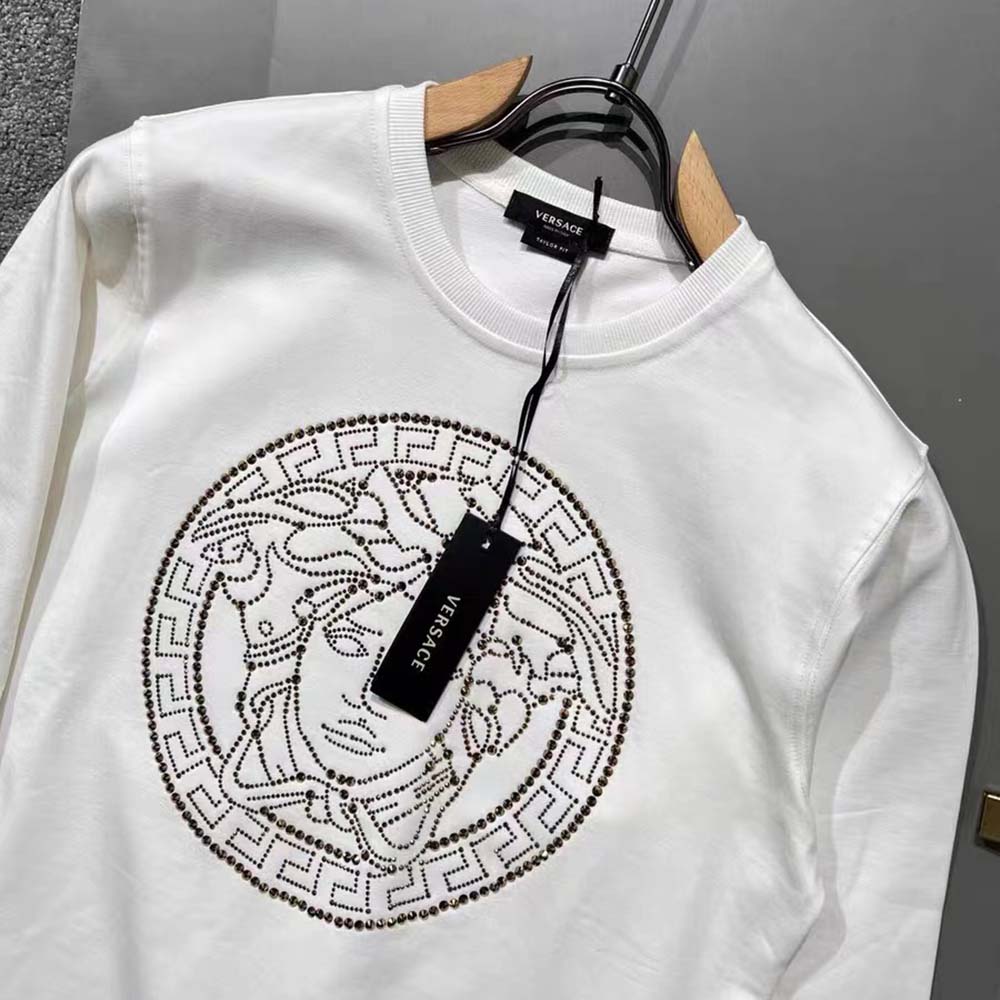 Side angle of Versace Men Embroidered Medusa Sliced Sweatshirt-White with ribbed cuffs