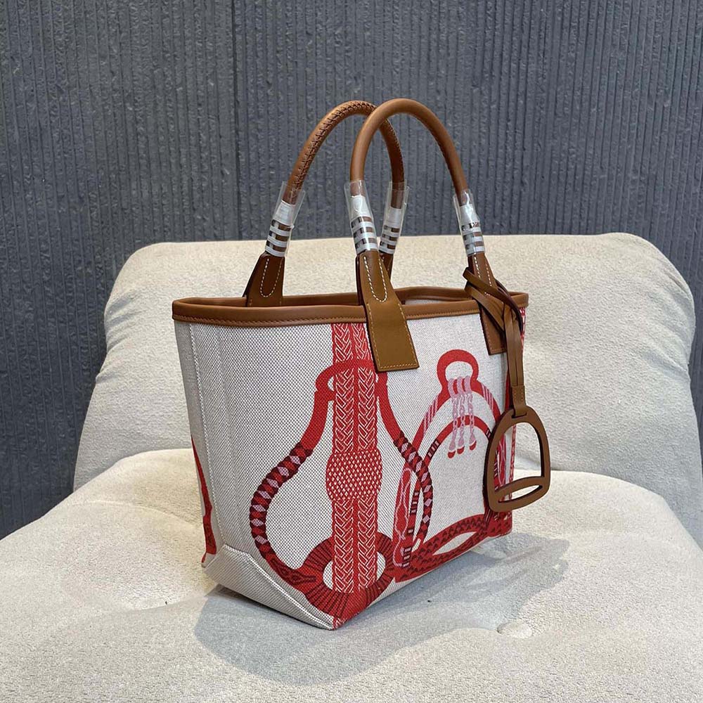 Side view showing compact silhouette of Hermes Unisex Steeple 25 Tote Bag-Orange