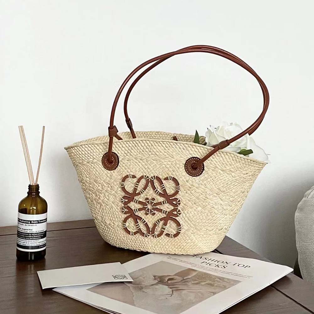 Side angle showing magnetic flap closure on Loewe Women Small Anagram Basket Bag