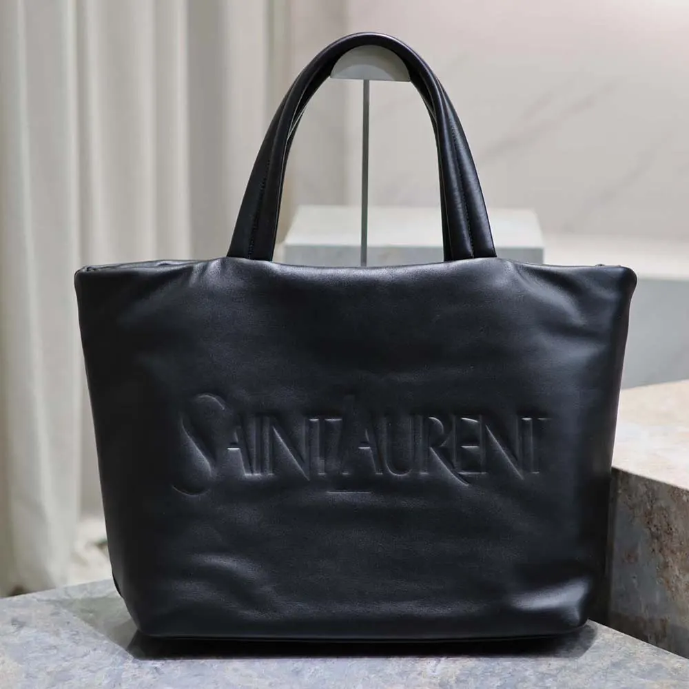 Close-up of gold YSL logo hardware on black lambskin tote