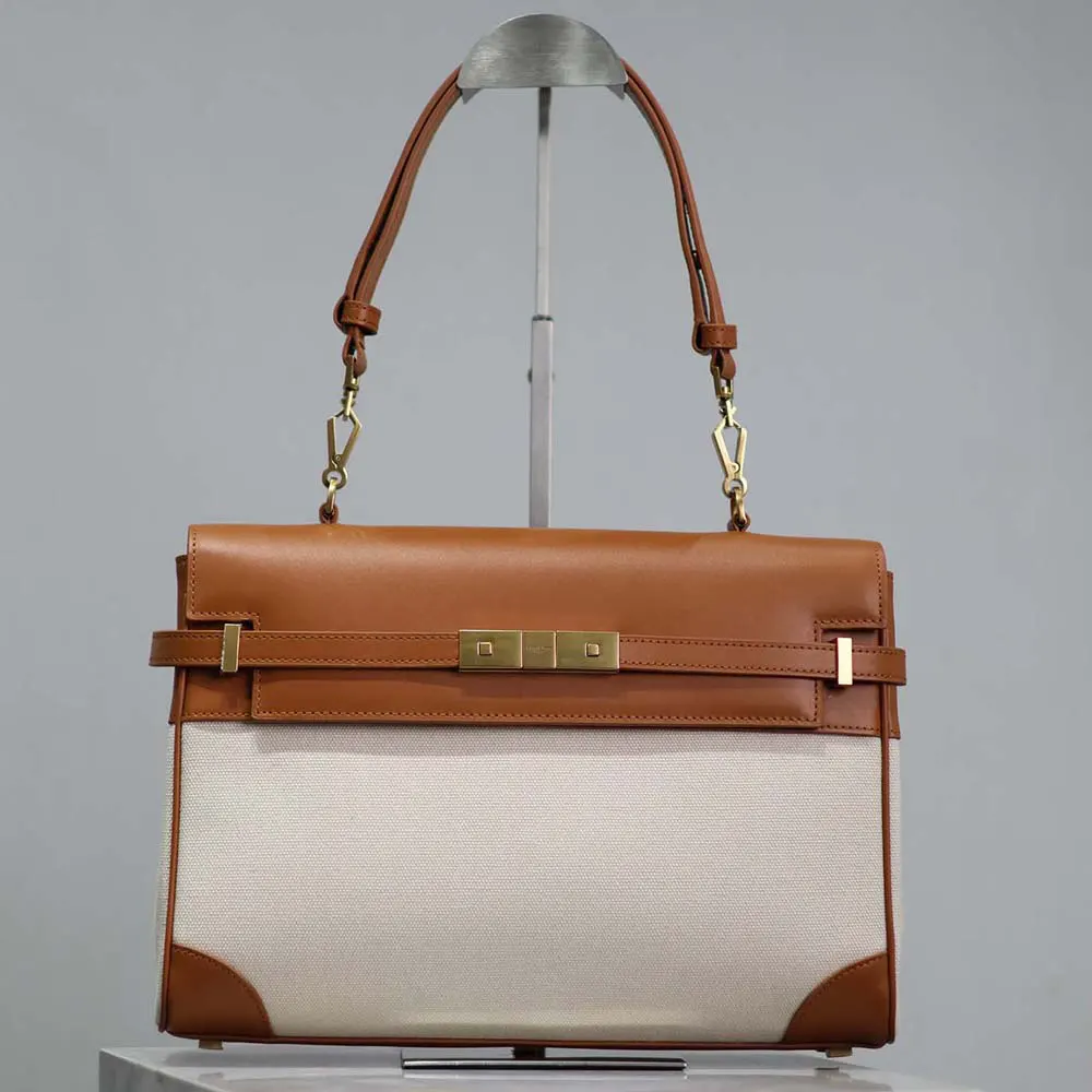Close-up of gold YSL logo on Manhattan Top Handle bag