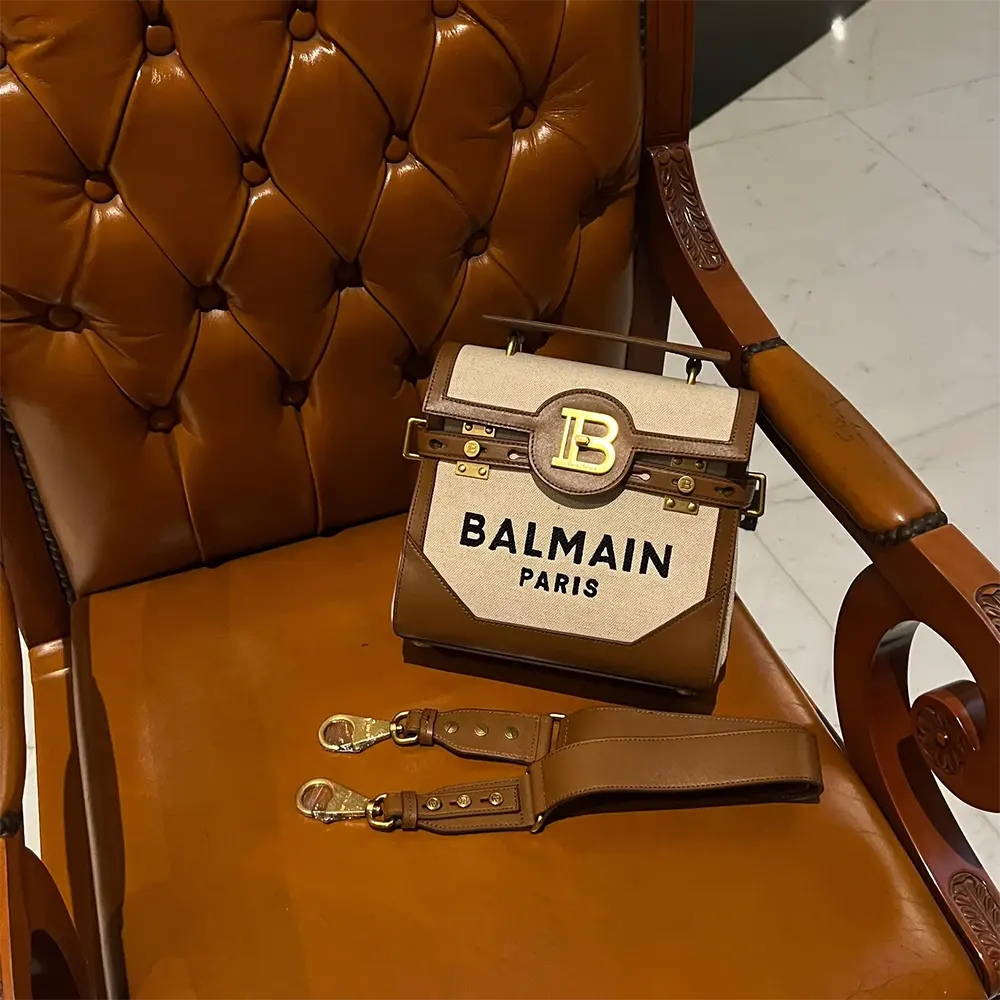 Side angle showing canvas and calfskin texture on Balmain B-Buzz Bag