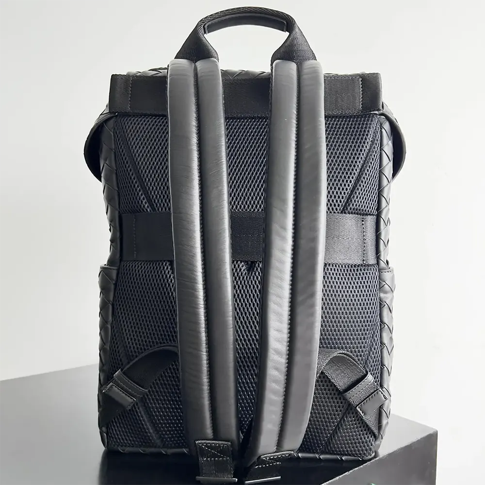 Side angle of Bottega Veneta Unisex Intrecciato Flap Backpack-Black with flap closure
