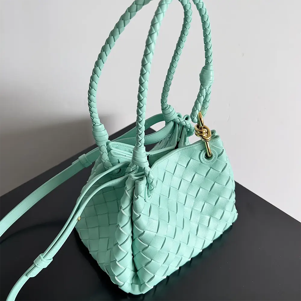 Side angle showing gold hardware and flap closure of Bottega Veneta Small Andiamo bag