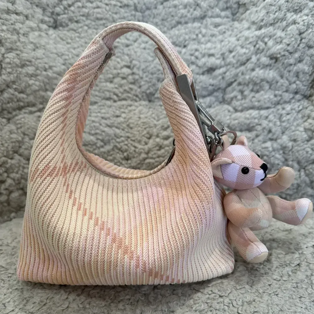 Side profile showing compact silhouette of Burberry Women Mini Peg Duffle Bag-Pink
