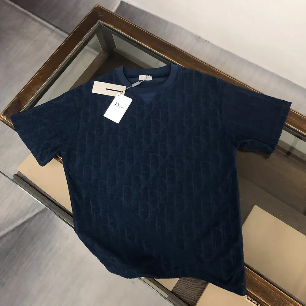 Close-up detail of navy blue Dior Oblique jacquard pattern on the t-shirt