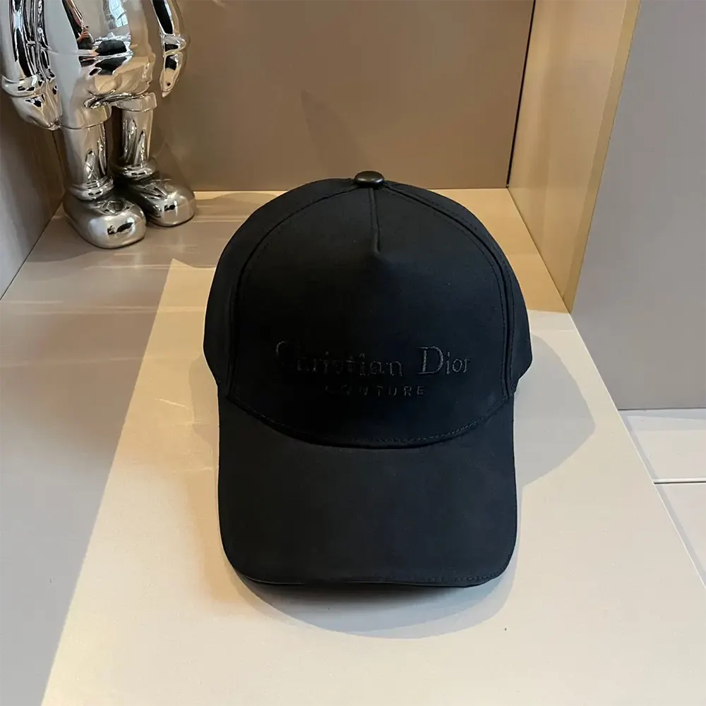 Close-up of embroidered Dior logo on black cotton canvas baseball cap