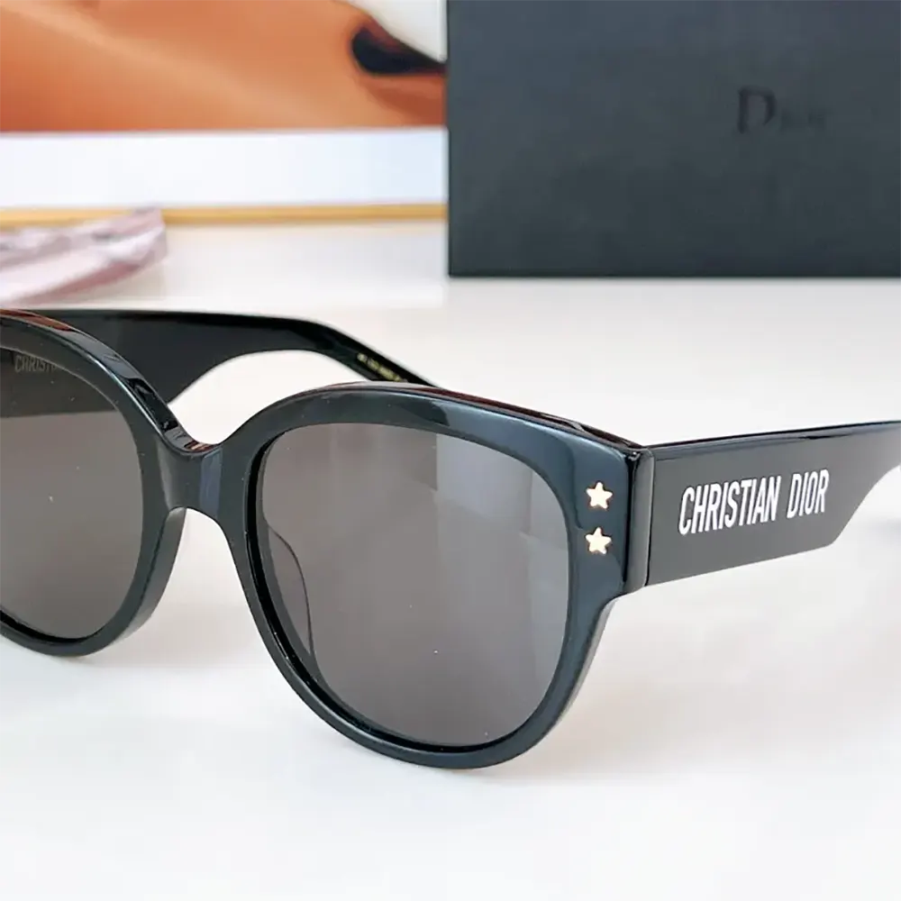 Close-up of black acetate frame and Dior metal detail on sunglasses