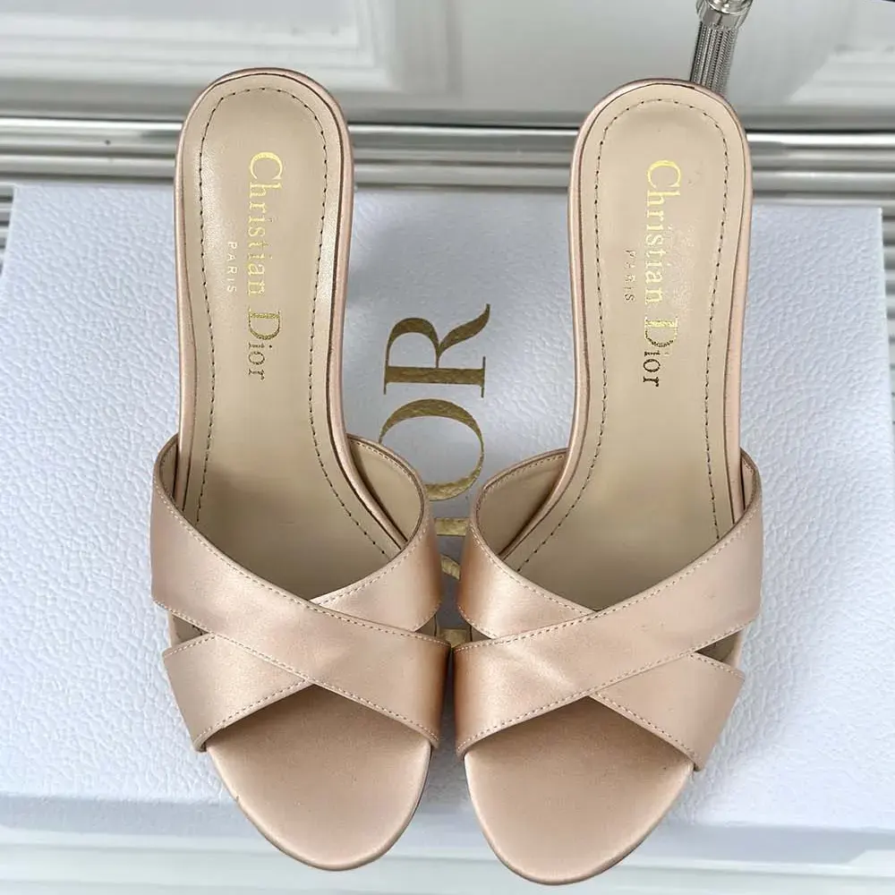 Close-up of Dior Tribales pearl detail on the pink satin heeled slide