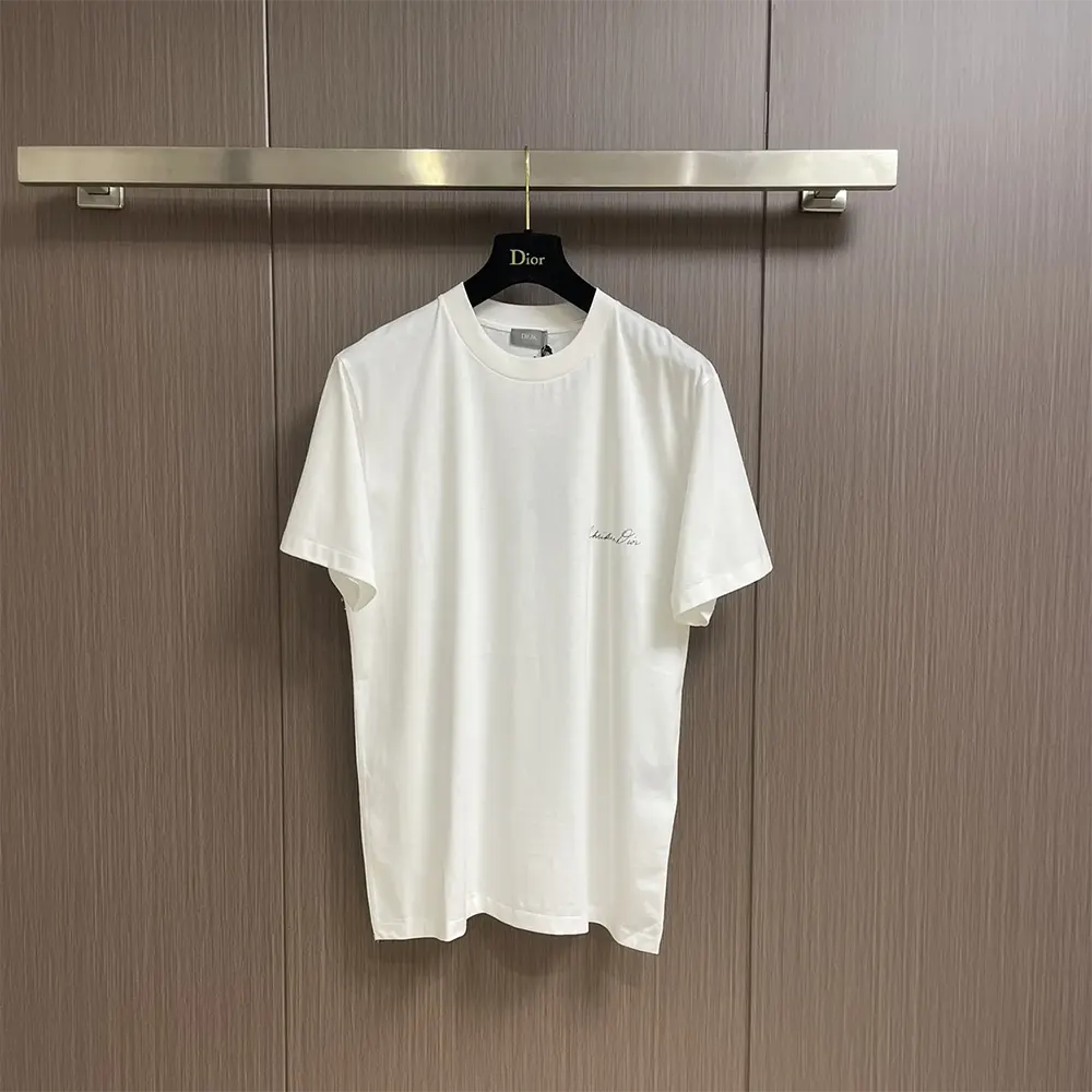 Close-up of handwritten Christian Dior logo on white T-shirt fabric