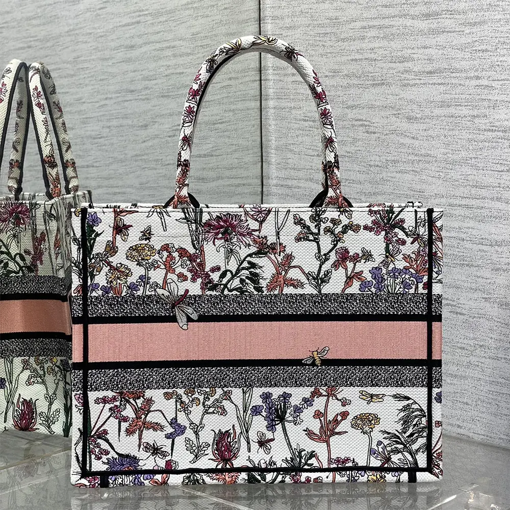 Side angle showing silver hardware and structured silhouette of Dior Book Tote