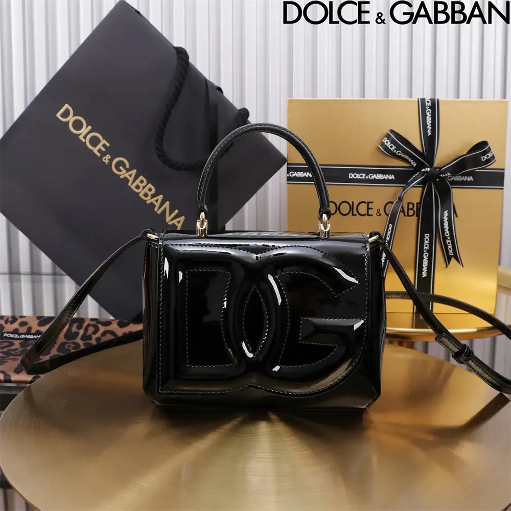 Close-up of gold-tone DG logo hardware on black top-handle bag