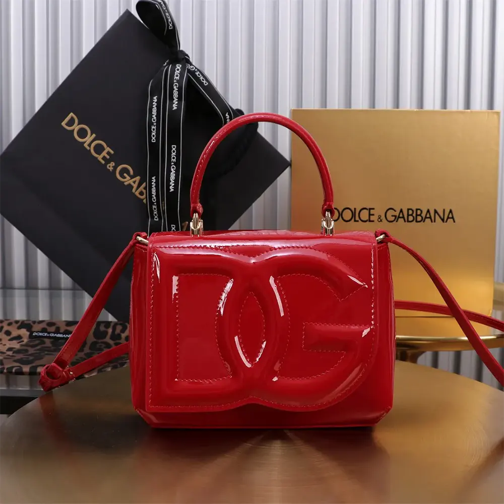 Close-up of gold DG logo hardware on red leather bag