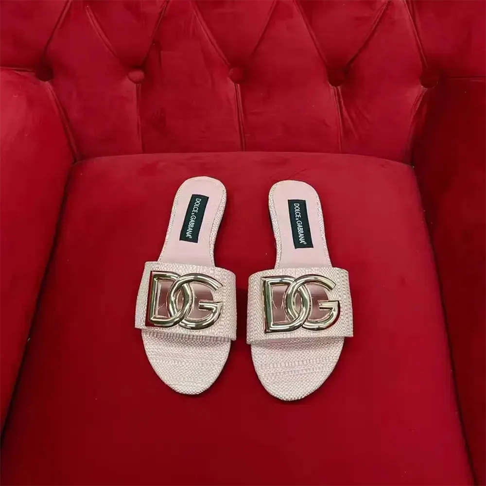 Close-up of gold-tone D&G hardware on pink raffia sliders