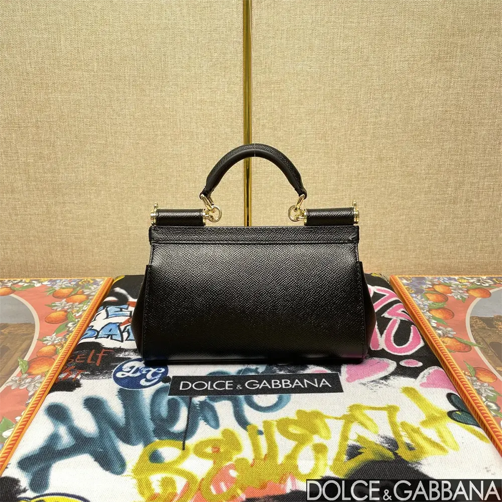 Side angle of small Sicily handbag showcasing smooth black leather texture