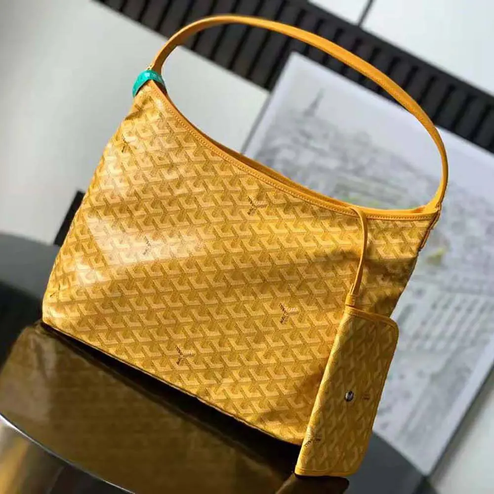 Close-up of yellow Goyard canvas and gold-tone hardware detailing