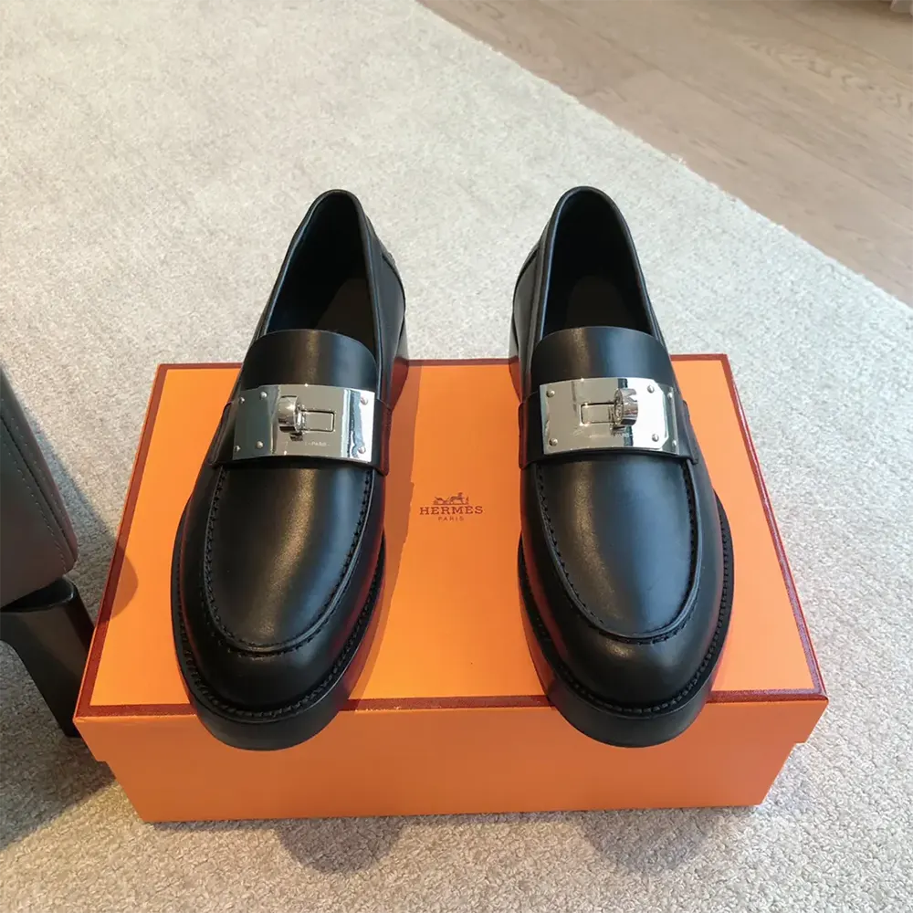 Close-up of signature Hermes hardware on hot loafer black leather