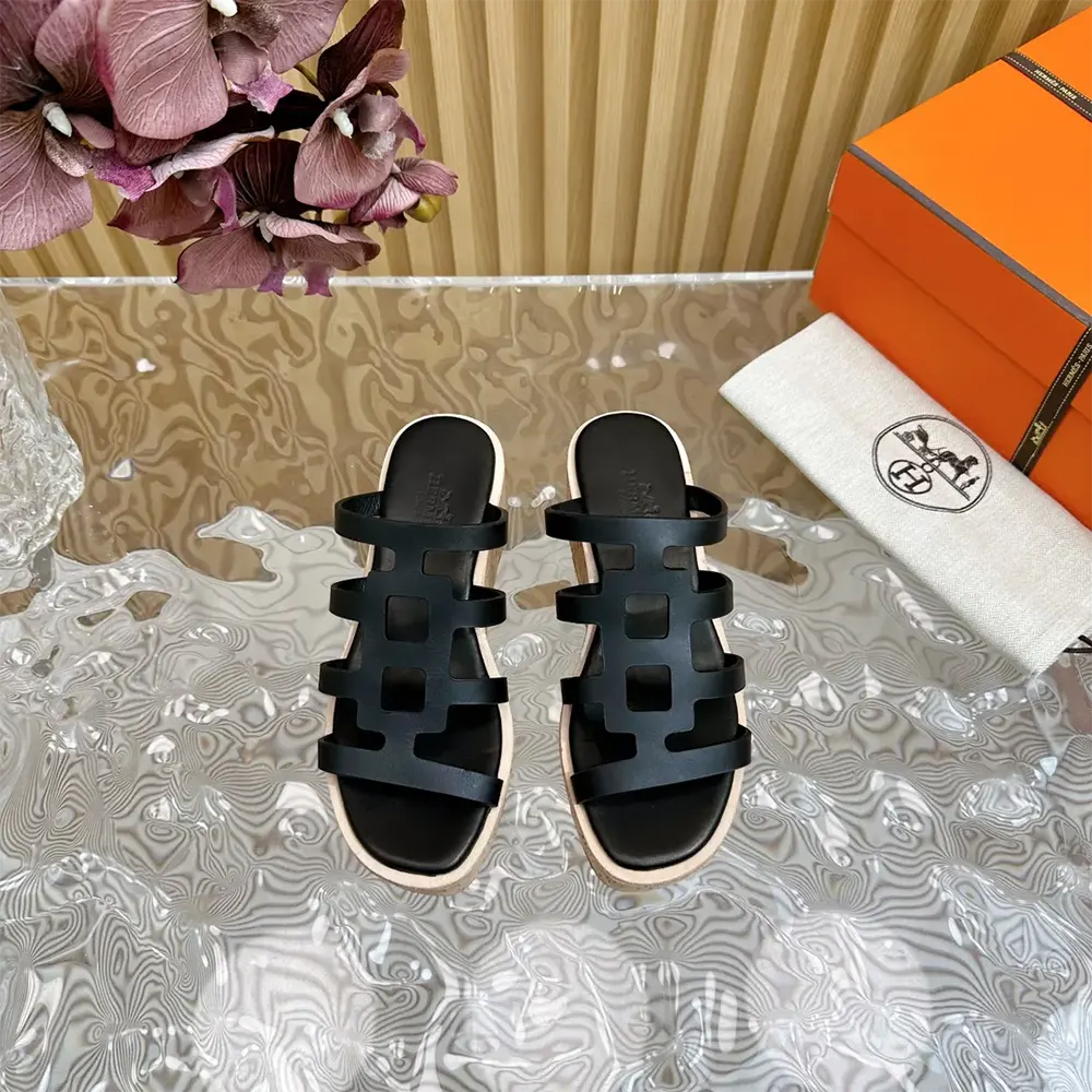 Close-up of black calfskin leather and silver hardware on Hermes sandal