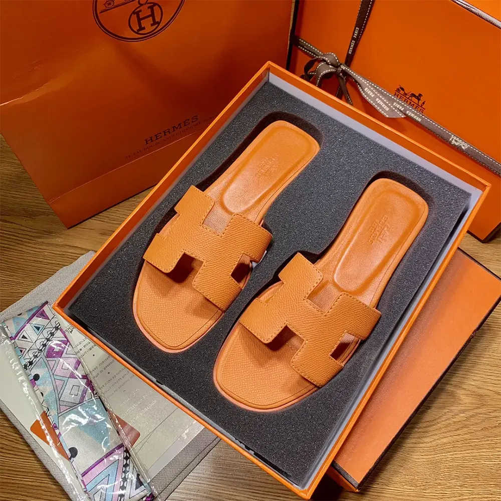 Overhead shot of Hermes Women Oran Sandal-Orange highlighting vibrant orange leather