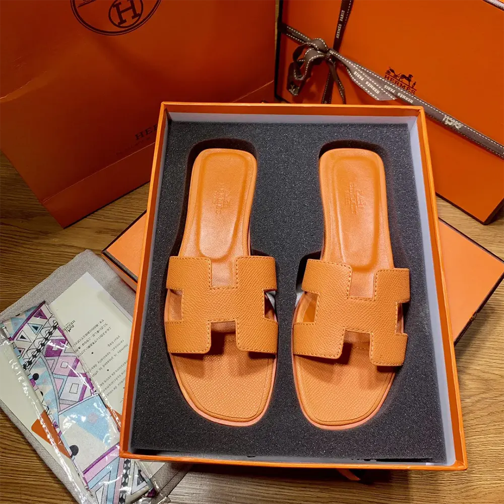 Close-up of signature 'H' cutout on Hermes Women Oran Sandal-Orange