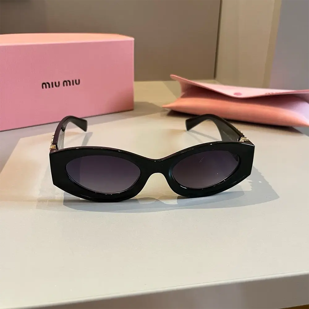 Close-up on silver Miu Miu logo hardware on black acetate frame