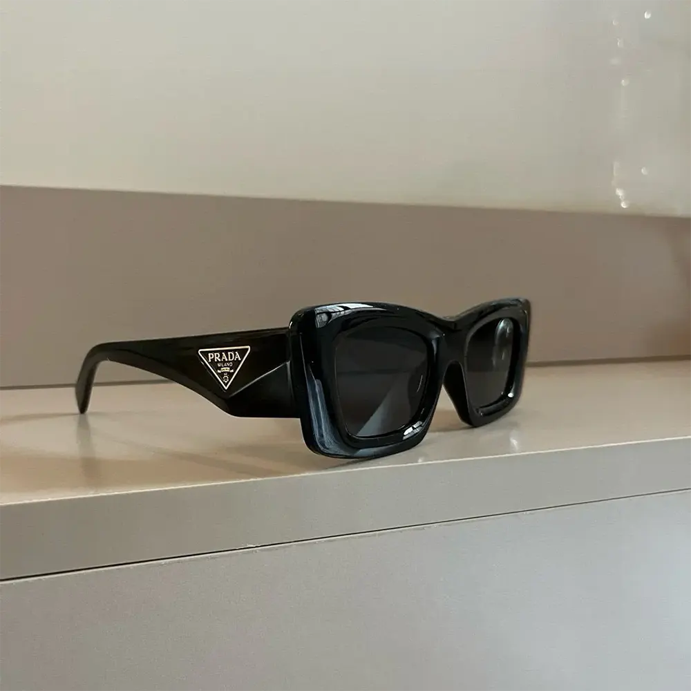 Close-up of the Prada triangle logo detail on sunglasses temple