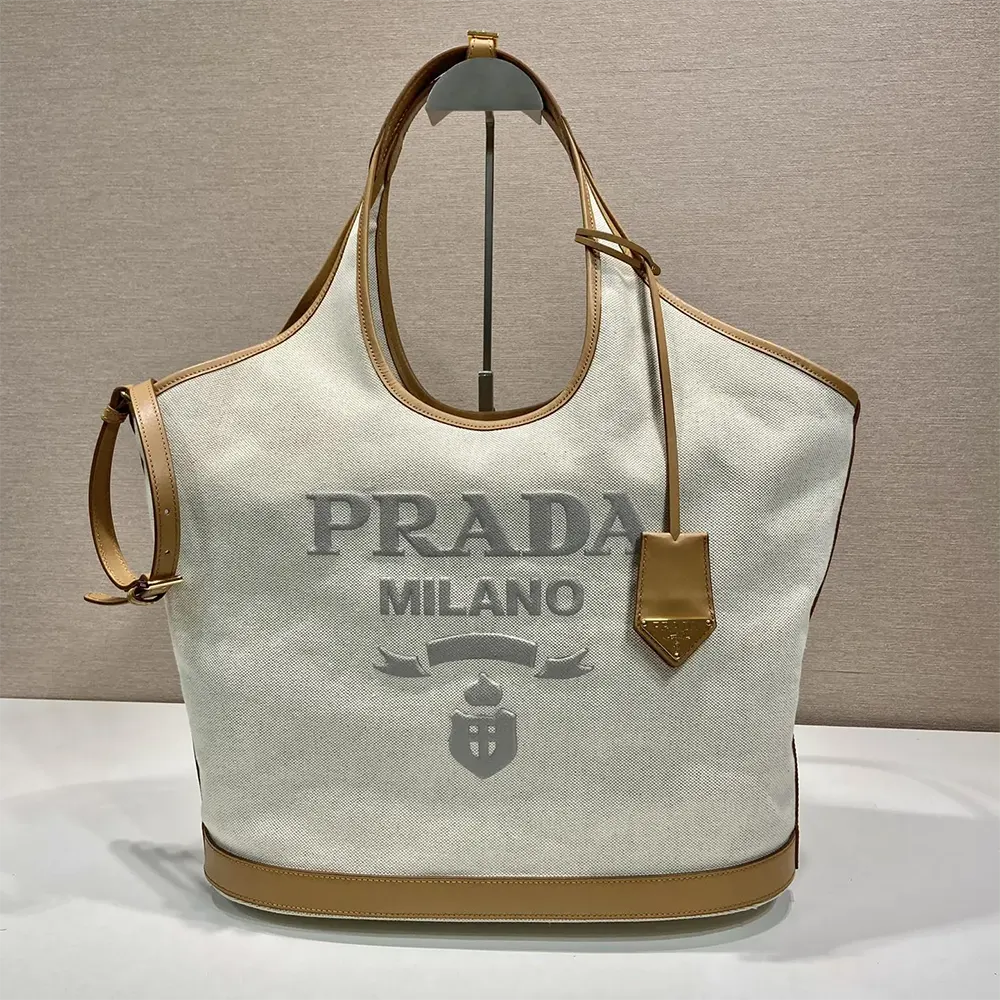 Close-up of gold-tone logo hardware on Prada Women Large Linen Blend and Leather Tote Bag