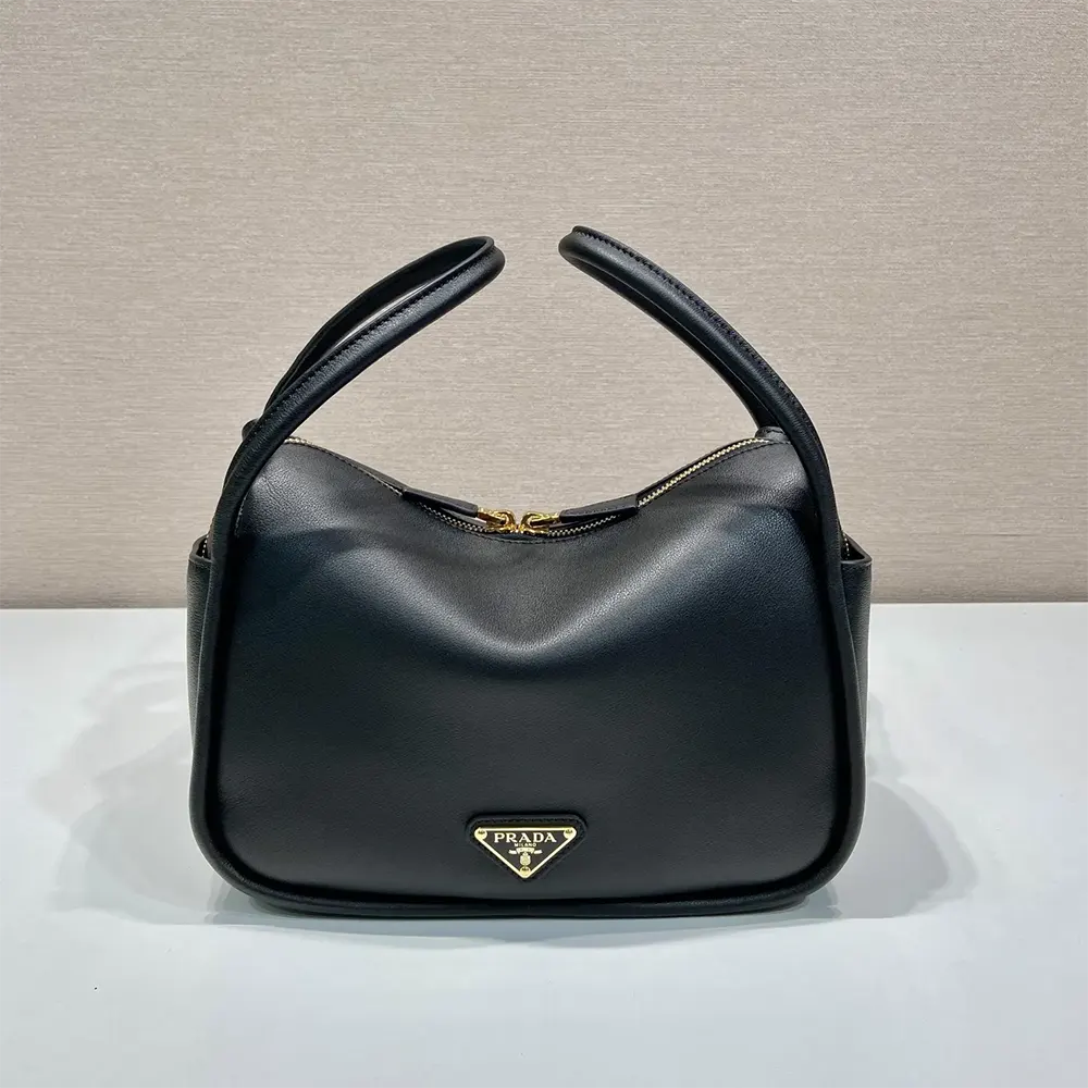 Close-up of polished silver Prada logo hardware on handbag flap