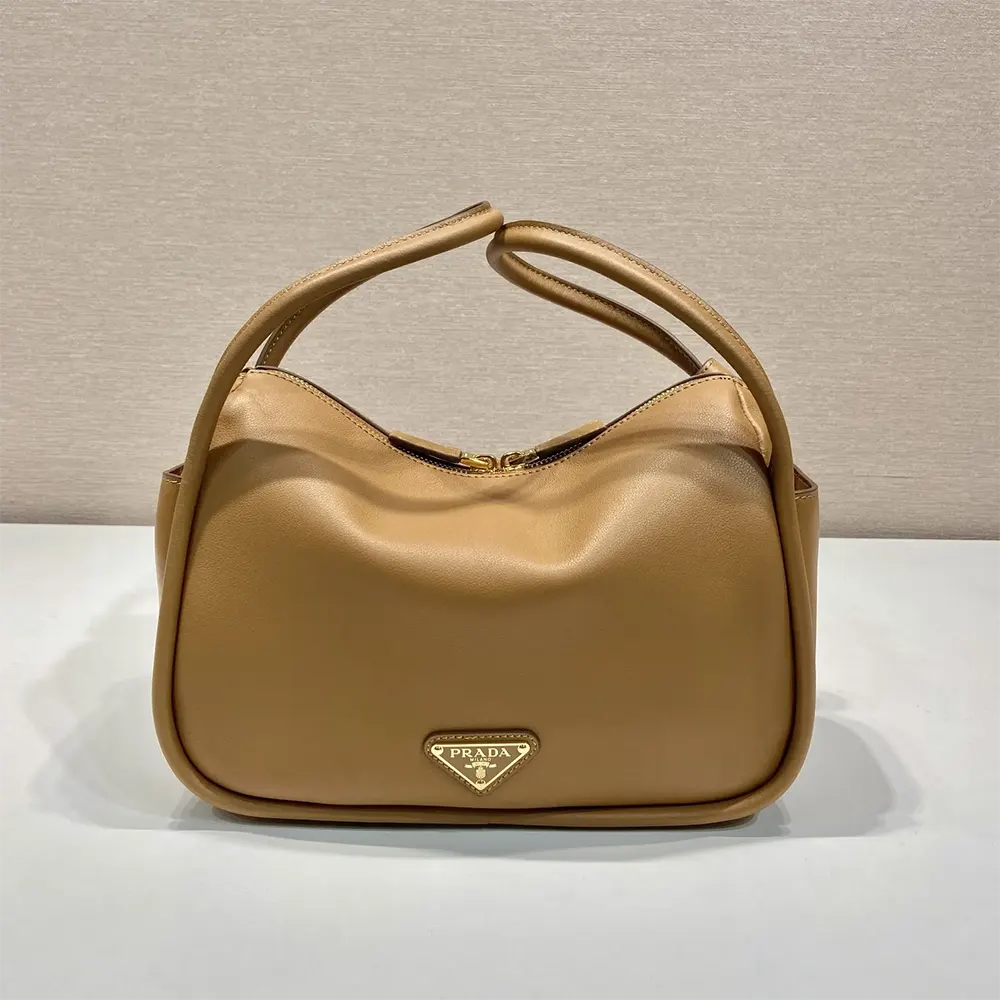Close-up of gold-tone Prada hardware on leather handbag in brown