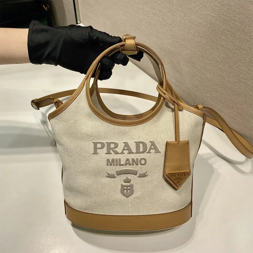 Side angle showing structured silhouette of Prada Women Medium Linen Blend and Leather Tote Bag