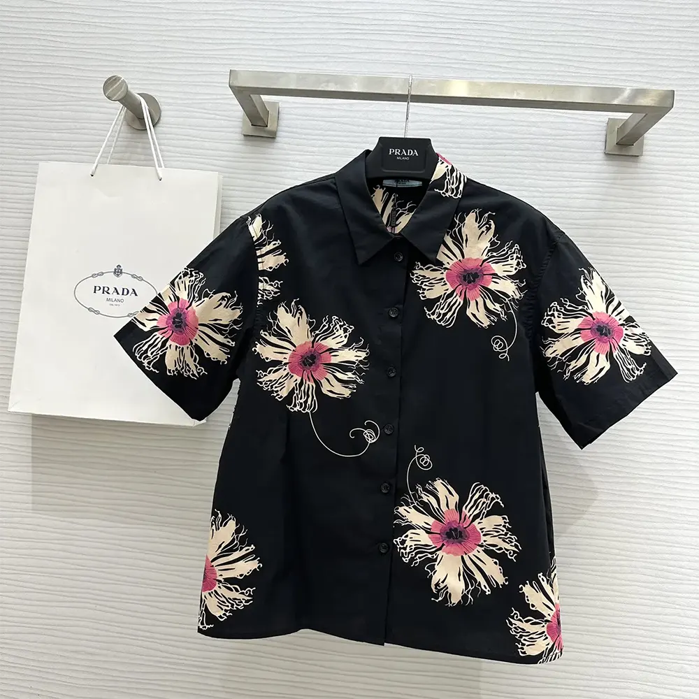 Close-up of button and signature detail on Prada Women Short-sleeved Printed Poplin Shirt