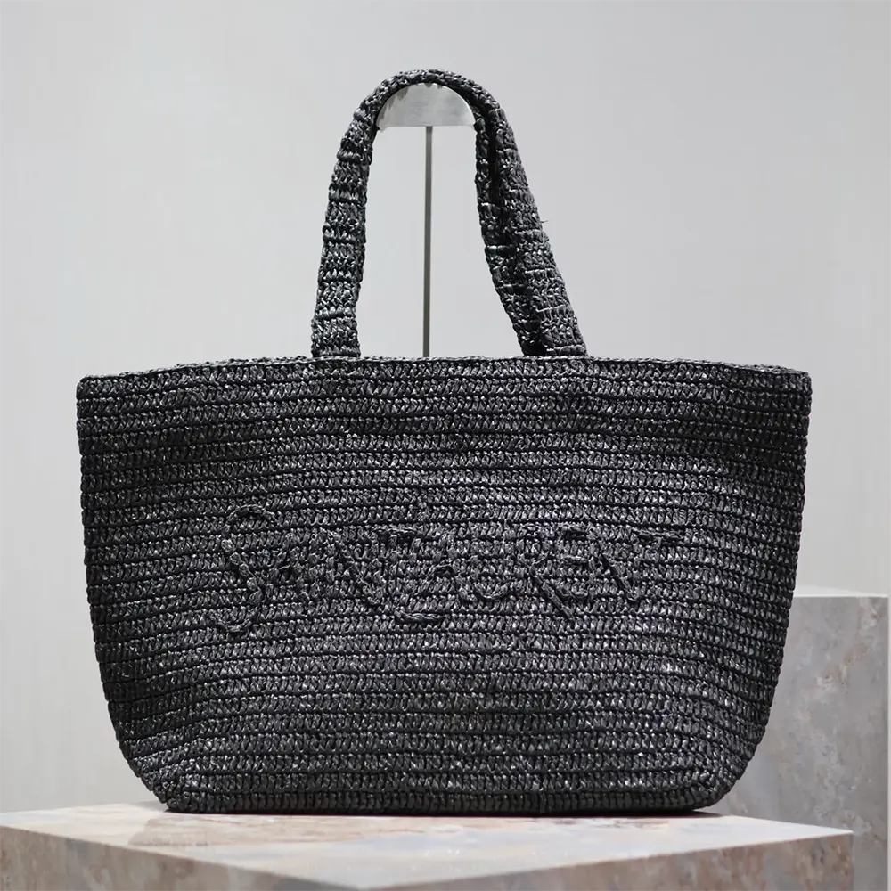 Close-up of black leather handles and gold YSL logo on raffia tote