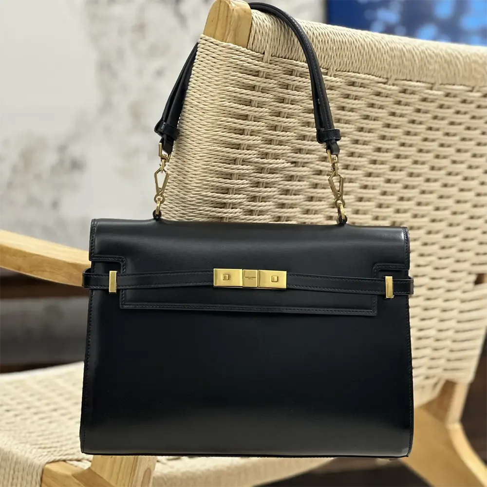 Close-up detail of gold YSL monogram and clasp on Manhattan Top-handle bag