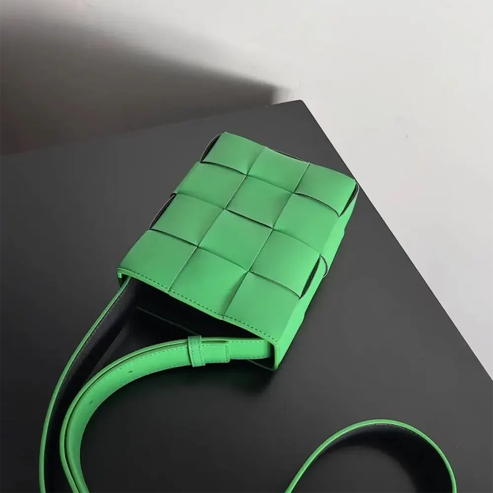 Side angle showing gold clasp and adjustable strap of green mini bag
