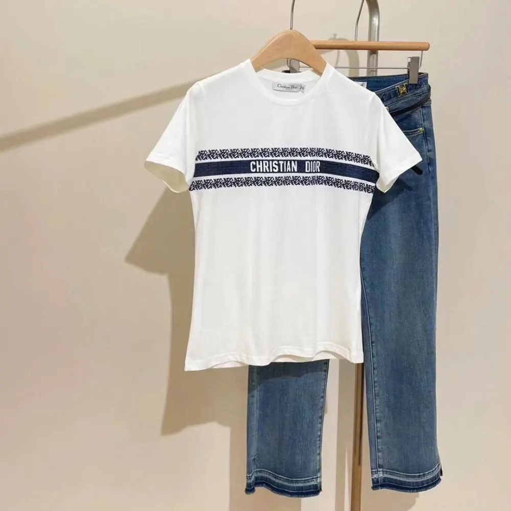 Close-up of Dior logo embroidery on white and navy blue t-shirt