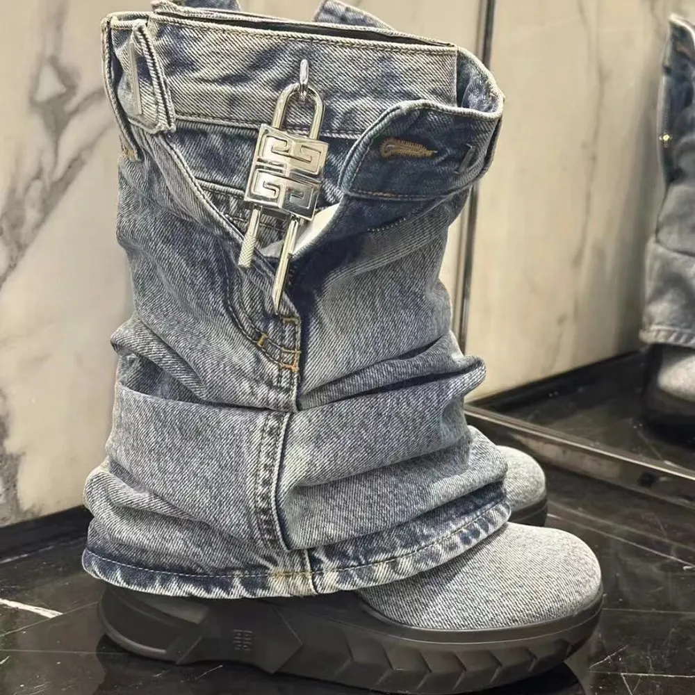 Close-up detail of silver shark lock hardware on Givenchy jeans boots
