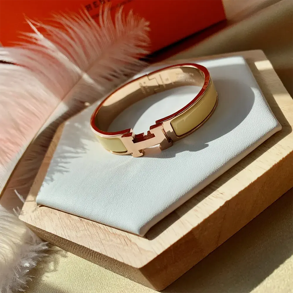 Close-up of Hermes Unisex Clic H Bracelet-Yellow gold-plated hardware detail