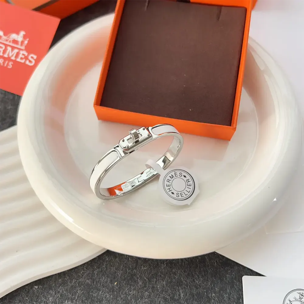 Side view showing slim profile of Hermes Unisex Mini Clic Kelly Bracelet-White