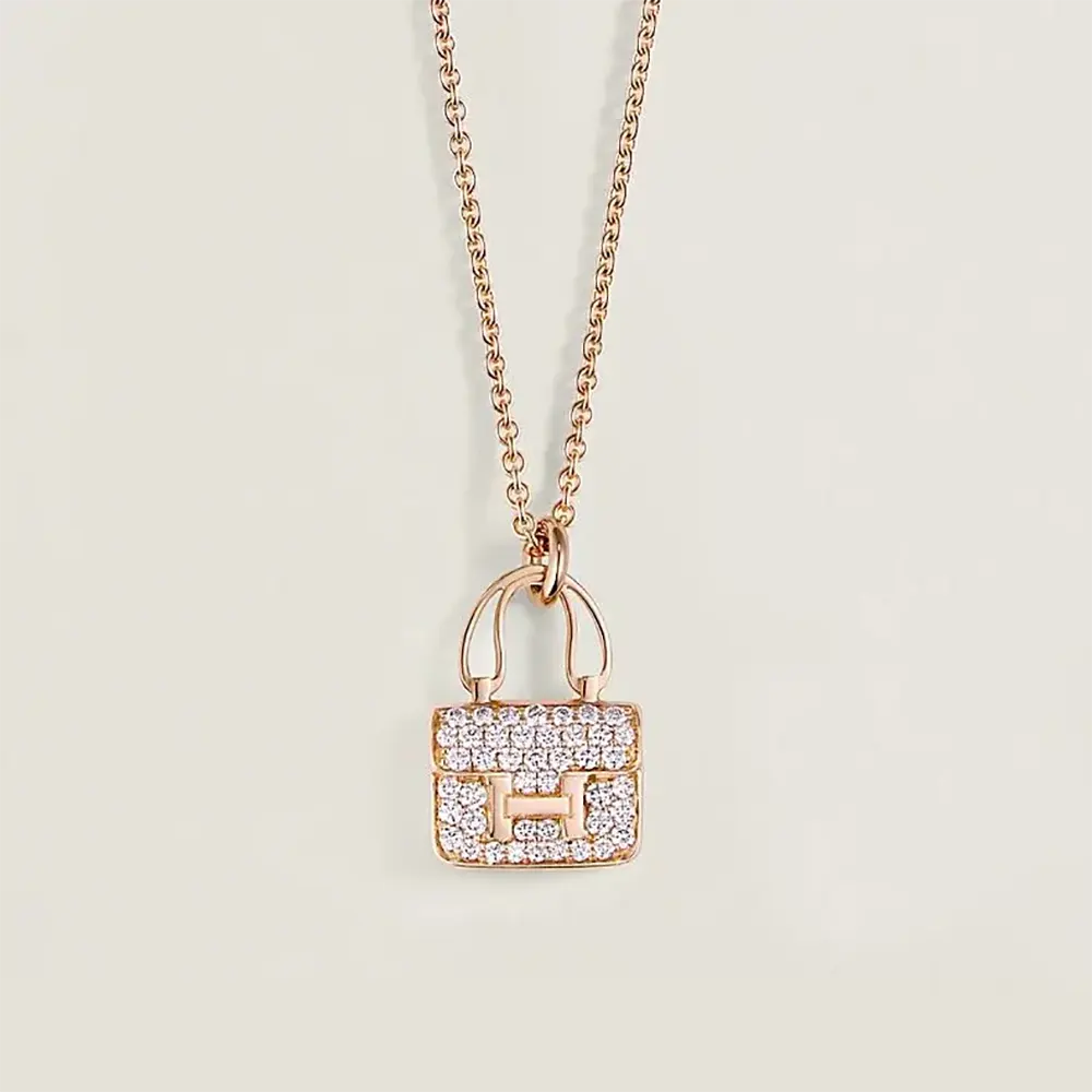 Close-up of Hermes Women Amulettes Constance Pendant showing gold clasp detail