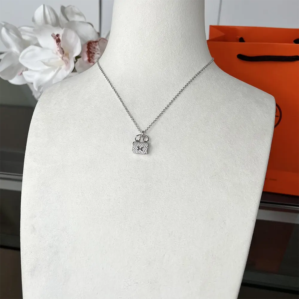 Side angle showing polished silver finish of Hermes Women Amulettes Constance Pendant