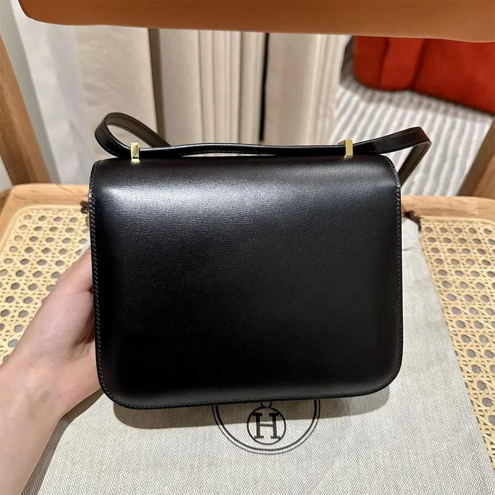 Side angle showing shoulder strap and silhouette of Hermes Women Constance 18 Bag