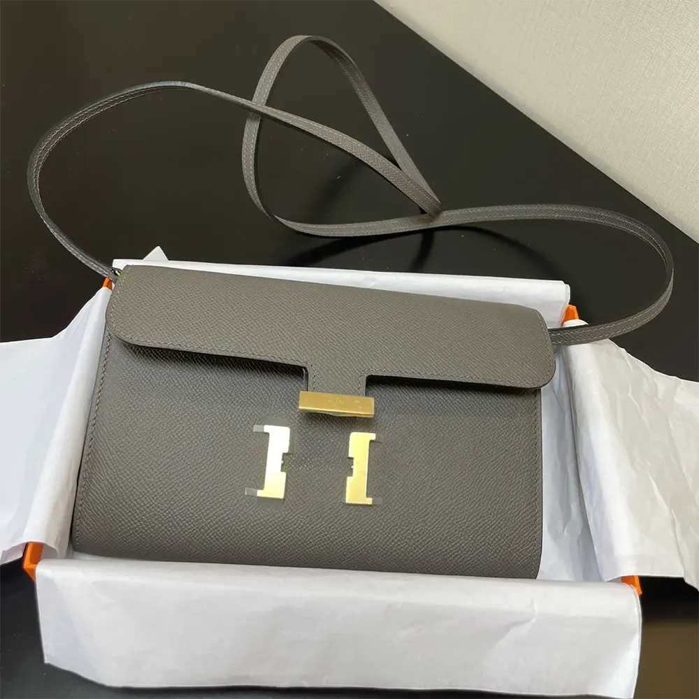 Side angle revealing slim profile of Hermes Women Constance Long To Go bag