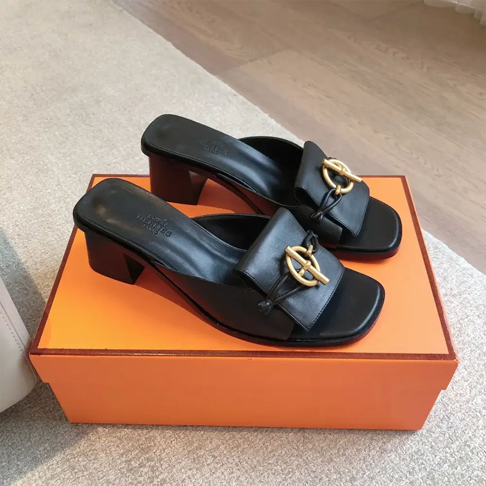 Close-up of signature buckle on Hermes Women Ilot 50 Sandal black calfskin