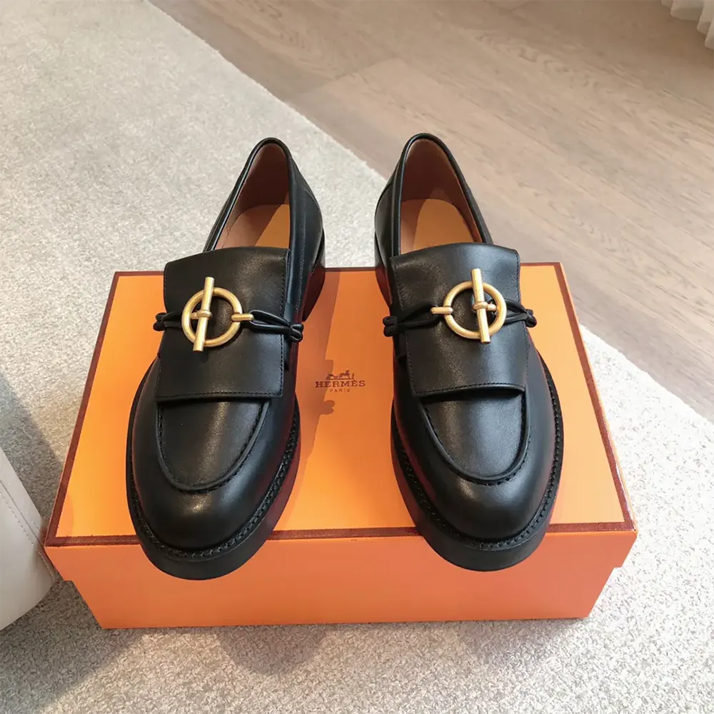 Close-up of embossed signature hardware on Hermes Women Impact Loafer
